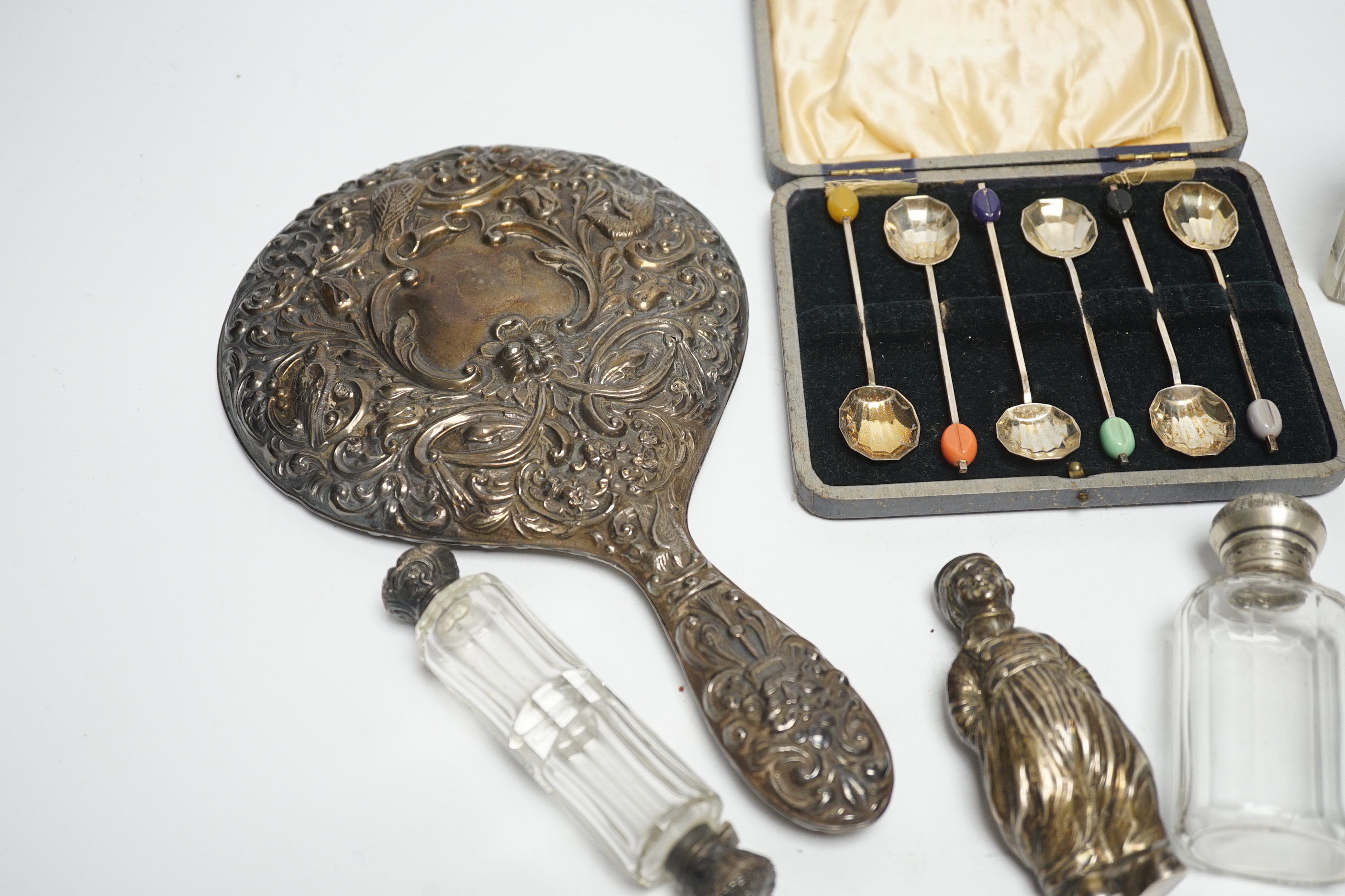 A Hanau silver novelty figural pepperette and other small silver including a silver mounted hand mirror, scent bottles and a small tyg and a cased set of plated spoons.